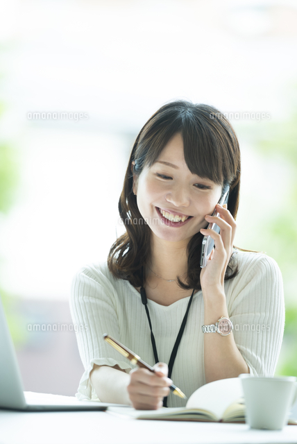 電話をしながらメモをとる女性社員 の写真素材 イラスト素材 アマナイメージズ