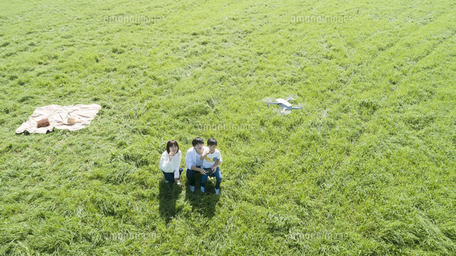 草原でドローンを操縦する親子 の写真素材 イラスト素材 アマナイメージズ