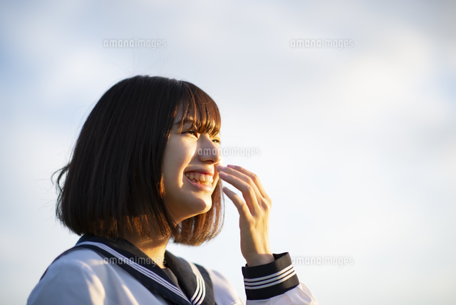 自然の中で笑う女子学生の横顔 の写真素材 イラスト素材 アマナイメージズ