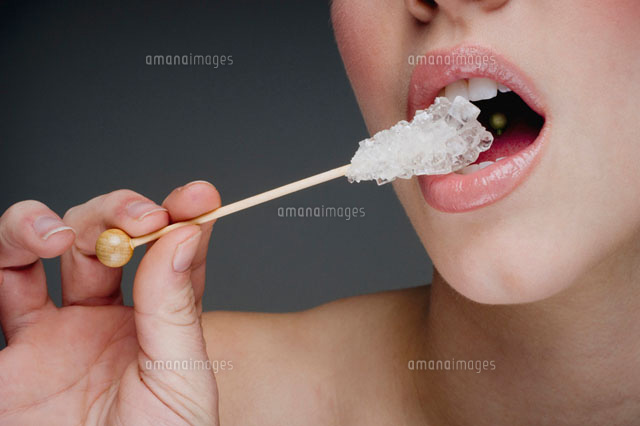 Woman eating rock candy[11018016452]の写真素材・イラスト素材｜アマナイメージズ