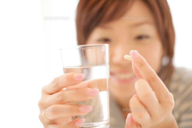 サプリメントを飲む女性 の写真素材 イラスト素材 アマナイメージズ