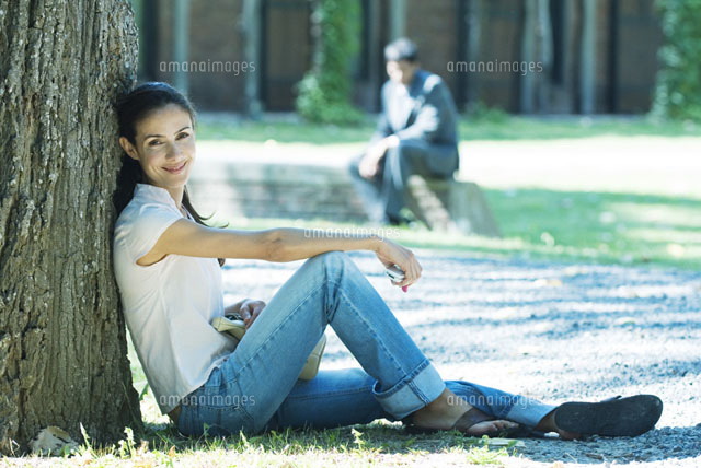 Woman sitting and leaning against tree[11025002473]の写真素材・イラスト素材｜アマナイメージズ