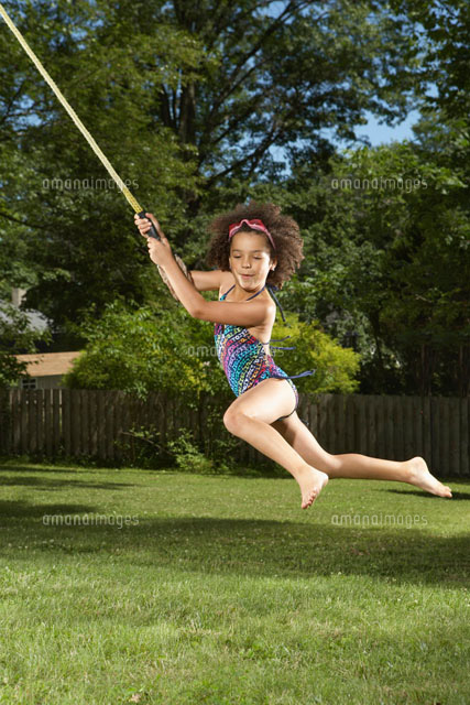Girl Swinging on Rope[11030025549]の写真素材・イラスト素材｜アマナイメージズ