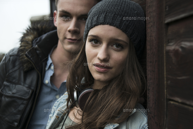 Close-up portrait of teenage girl and young man outdoors, looking at ...