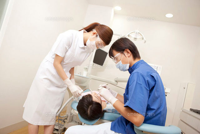 女性患者の治療をする男性歯科医と歯科衛生士 の写真素材 イラスト素材 アマナイメージズ