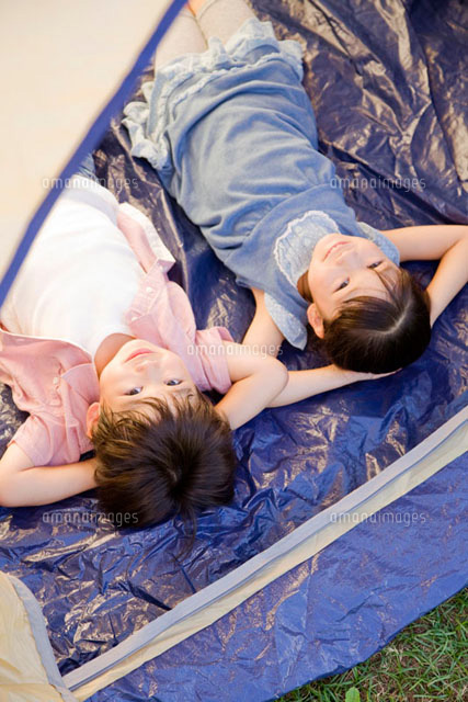 テントに寝転んで空を見上げる男の子と女の子 の写真素材 イラスト素材 アマナイメージズ