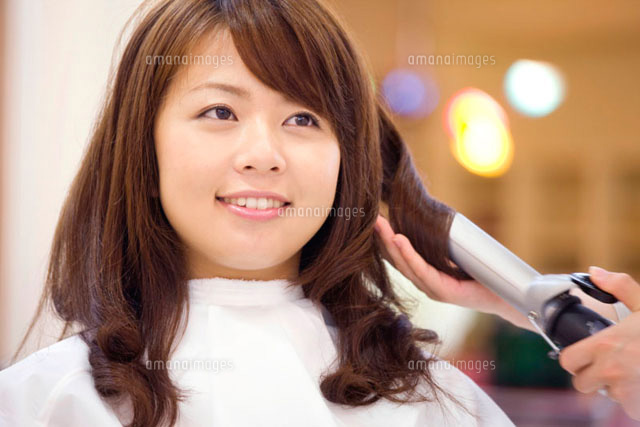 美容師にヘアアイロンをしてもらう女性 の写真素材 イラスト素材 アマナイメージズ