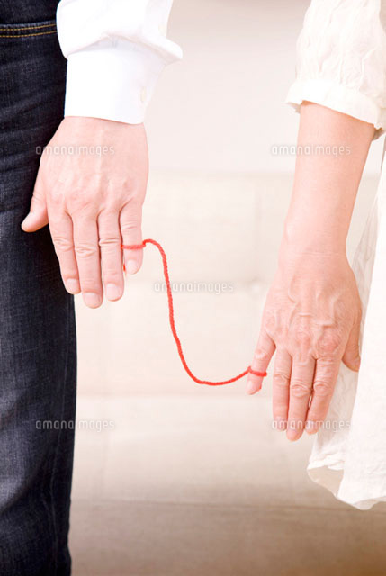 赤い糸で繋がったシニアカップルの手元 の写真素材 イラスト素材 アマナイメージズ