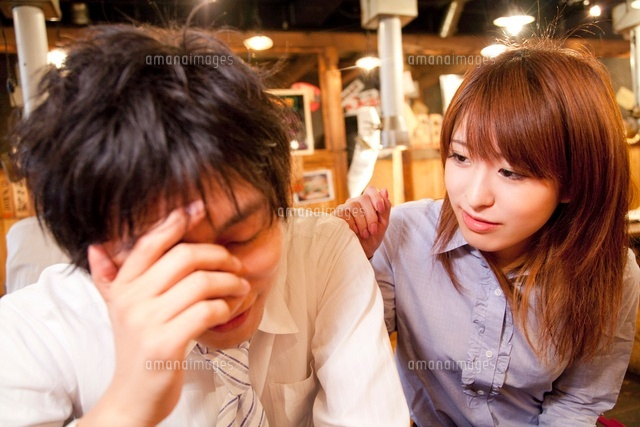 居酒屋で落ち込む男性と慰める女性 の写真素材 イラスト素材 アマナイメージズ