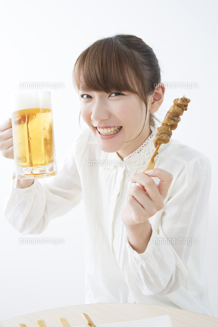 ビールと焼き鳥を持つ女性 の写真素材 イラスト素材 アマナイメージズ