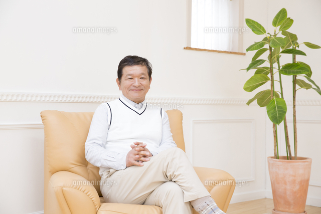 ソファに座って微笑む男性 の写真素材 イラスト素材 アマナイメージズ