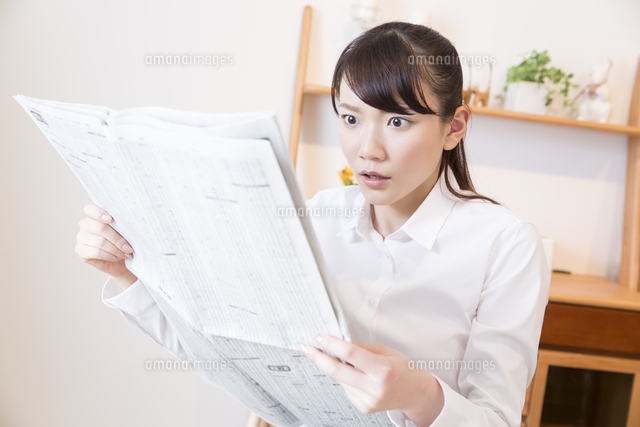 新聞を読んで驚く女性 の写真素材 イラスト素材 アマナイメージズ