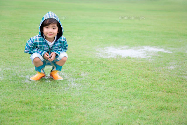 草原の水たまりと合羽を着た男の子 の写真素材 イラスト素材 アマナイメージズ