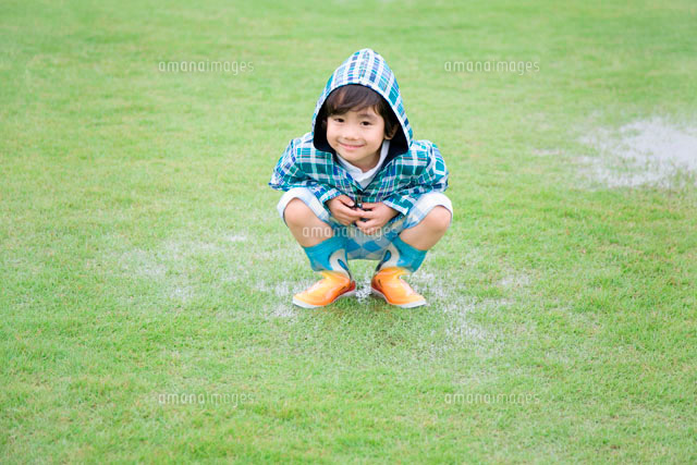 草原の水たまりと合羽を着た男の子 の写真素材 イラスト素材 アマナイメージズ