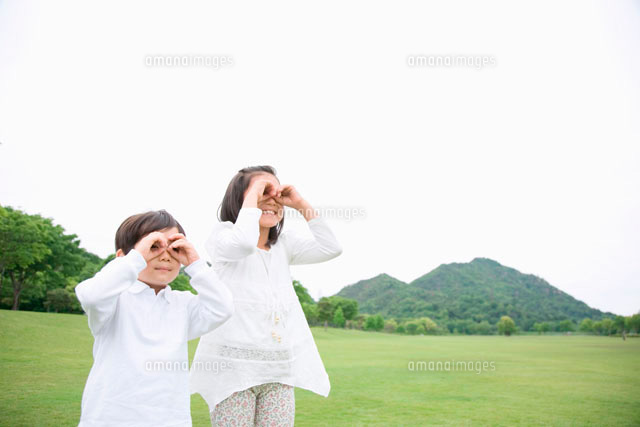 手で作った輪で遠くを見る姉弟 の写真素材 イラスト素材 アマナイメージズ