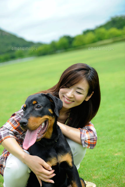 犬と触れ合う女性[11032006251]の写真・イラスト素材｜アマナイメージズ