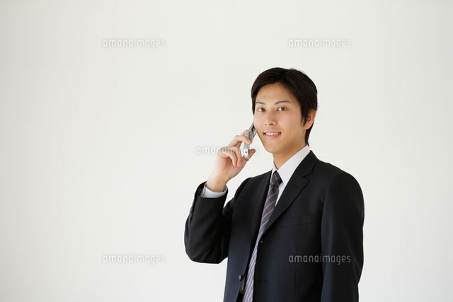 携帯電話をかけるスーツ姿の男性 の写真素材 イラスト素材 アマナイメージズ