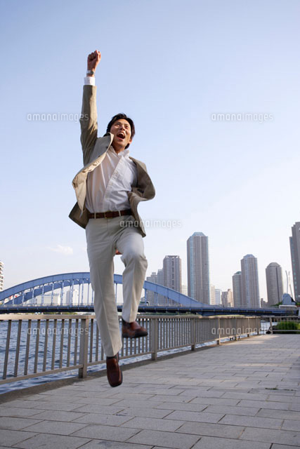 ガッツポーズで飛び上がるスーツ姿の男性 の写真素材 イラスト素材 アマナイメージズ