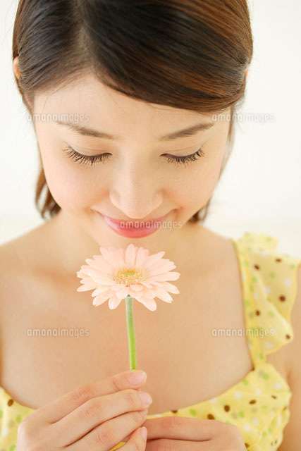 ガーベラの花を持つ女性[11038001848]の写真・イラスト素材｜アマナ