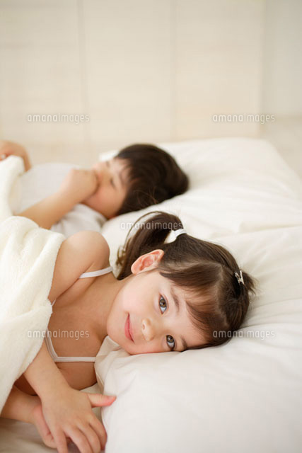 ベッドで横になる女の子 の写真素材 イラスト素材 アマナイメージズ