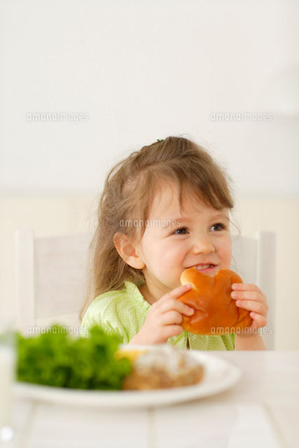 パンを食べる女の子[11038002729]の写真・イラスト素材｜アマナイメージズ
