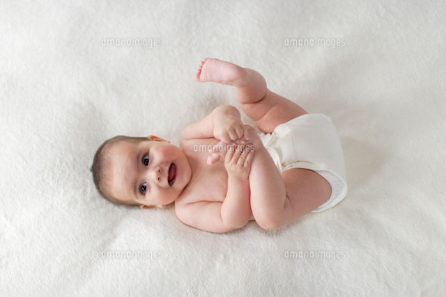 ブランケットの上で仰向けでゴロゴロする赤ちゃん の写真素材 イラスト素材 アマナイメージズ