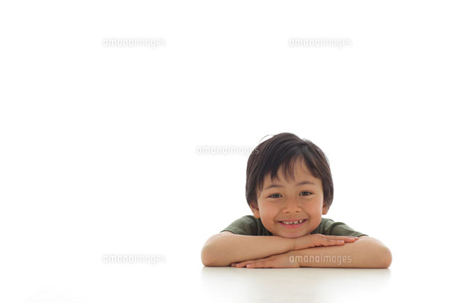 机にもたれる男の子 の写真素材 イラスト素材 アマナイメージズ