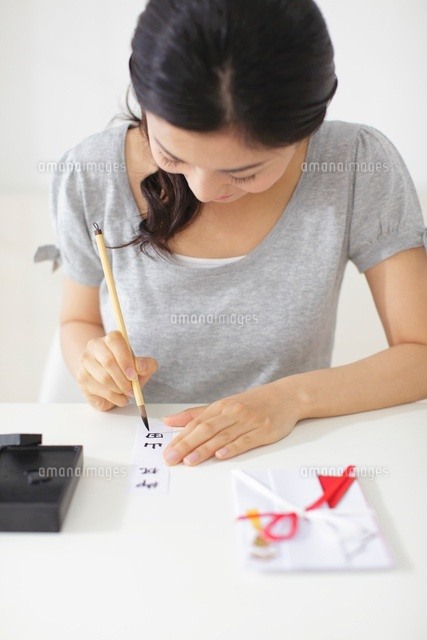 祝儀袋に文字を書く女性 の写真素材 イラスト素材 アマナイメージズ