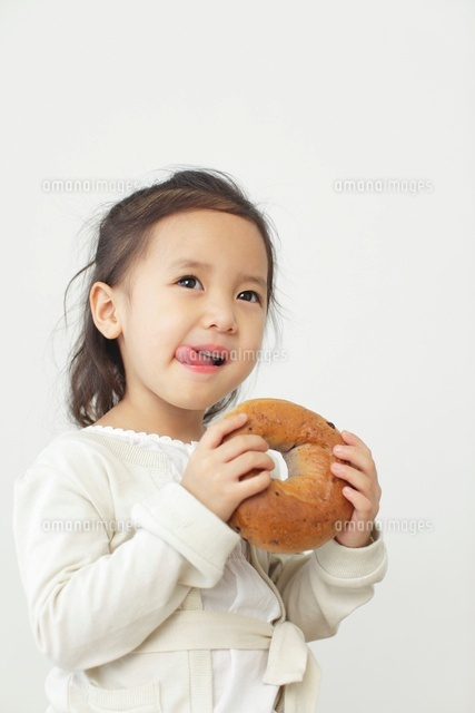 ベーグルを食べる女の子 の写真素材 イラスト素材 アマナイメージズ