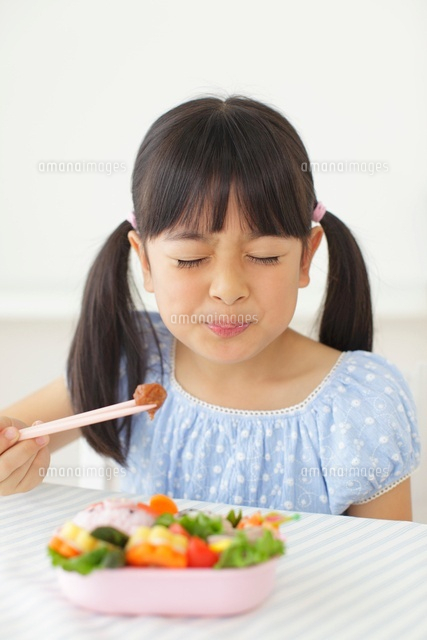 弁当の梅干しを食べる女の子 の写真素材 イラスト素材 アマナイメージズ