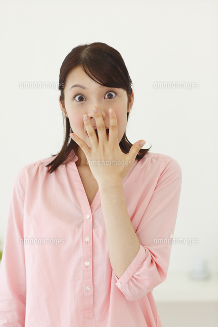 ビックリして口をふさぐ若い女性 の写真素材 イラスト素材 アマナイメージズ