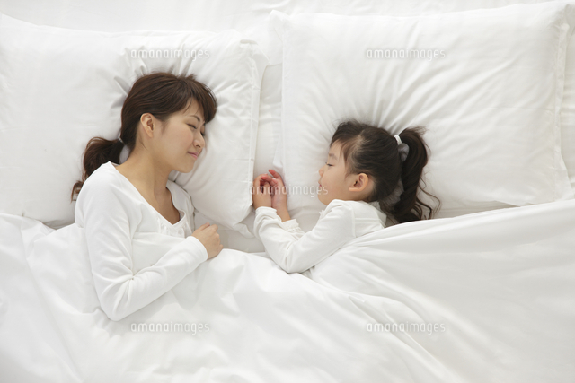白い布団で眠るお母さんと女の子 の写真素材 イラスト素材 アマナイメージズ