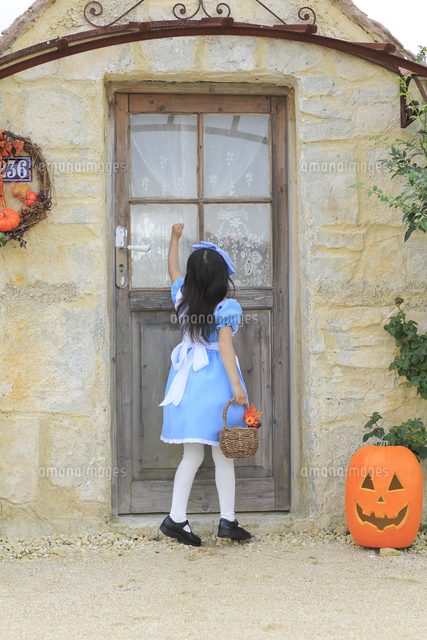 ハロウィンの仮装をして家を訪ねる女の子 の写真素材 イラスト素材 アマナイメージズ