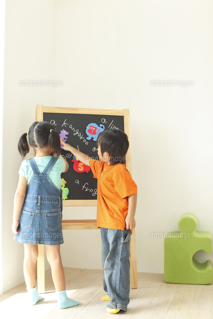 黒板を指差す男の子と女の子 の写真素材 イラスト素材 アマナイメージズ