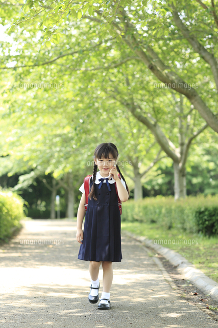 携帯電話で通話するランドセルの小学生の女の子 の写真素材 イラスト素材 アマナイメージズ