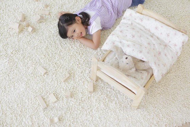 ぬいぐるみをおもちゃのベッドに寝かせてお昼寝する女の子 の写真素材 イラスト素材 アマナイメージズ