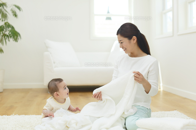 洗濯物をたたむお母さんと赤ちゃん の写真素材 イラスト素材 アマナイメージズ