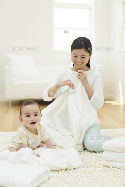 洗濯物をたたむお母さんと赤ちゃん の写真素材 イラスト素材 アマナイメージズ