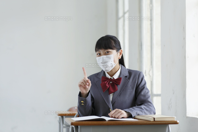 マスクをして授業中に案内ポーズをする女子高生 の写真素材 イラスト素材 アマナイメージズ