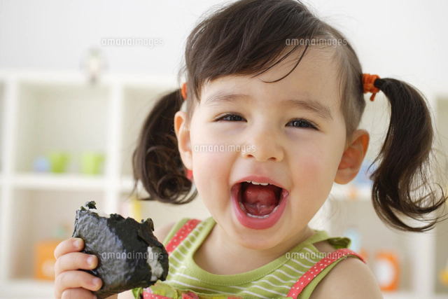 美味しそうにパンを食べる女の子[11038024138]の写真・イラスト素材