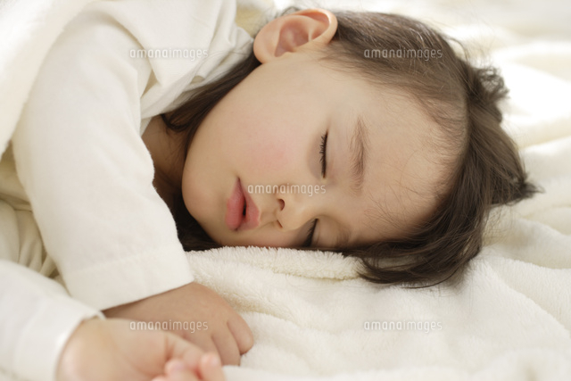 白いブランケットに包まれて眠る女の子 の写真素材 イラスト素材 アマナイメージズ