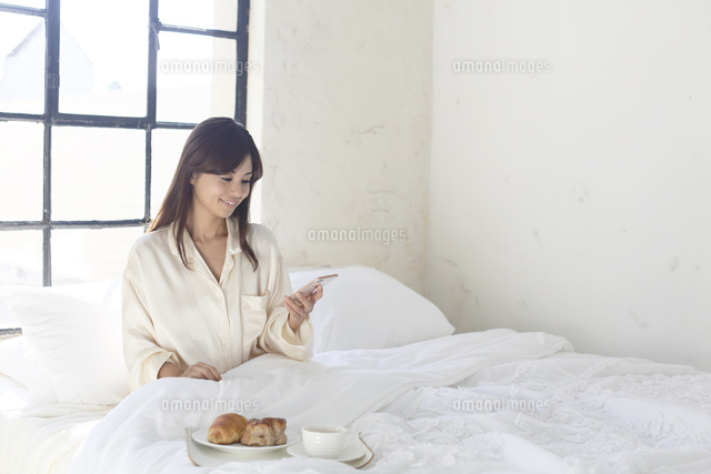 広いベッドルームで携帯を見ながら朝食を食べる女性 の写真素材 イラスト素材 アマナイメージズ 広いベッドルームで携帯を見ながら朝食を食べる女性 の写真素材 イラスト素材 アマナイメージズ