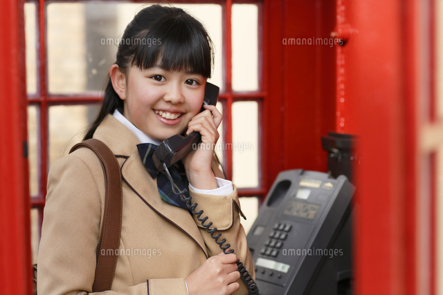 赤い電話ボックスと制服の女の子 の写真素材 イラスト素材 アマナイメージズ