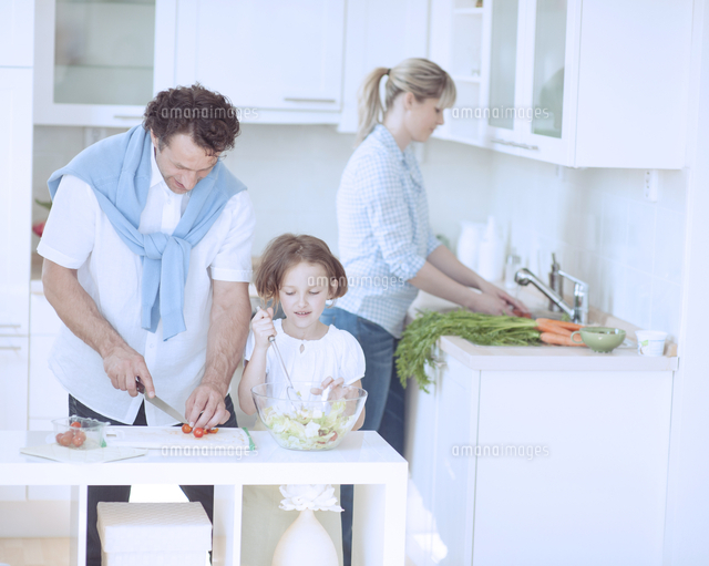 Family preparing healthy meal in kitchen[11044024318]の写真素材・イラスト素材｜アマナイメージズ
