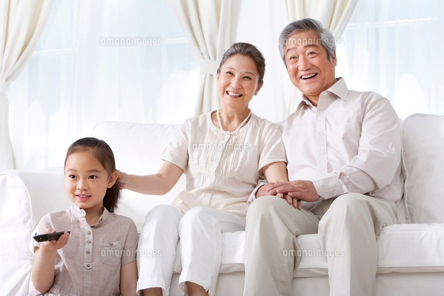 テレビを見る祖父母と孫娘 の写真素材 イラスト素材 アマナイメージズ