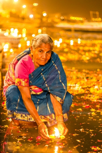 火をつけた花を川に流す女性 の写真素材 イラスト素材 アマナイメージズ