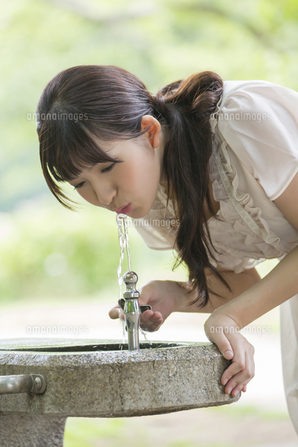 水道の水を飲む若い女性 の写真素材 イラスト素材 アマナイメージズ
