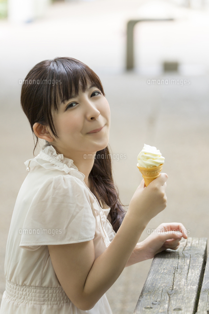 ソフトクリームを食べる若い女性 の写真素材 イラスト素材 アマナイメージズ