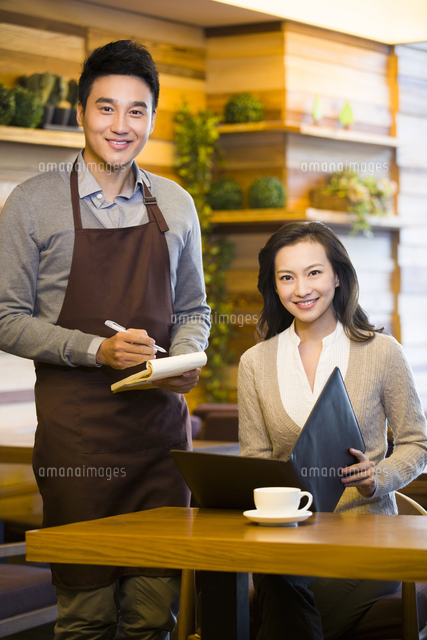 レストランで注文をする女性と店員 の写真素材 イラスト素材 アマナイメージズ