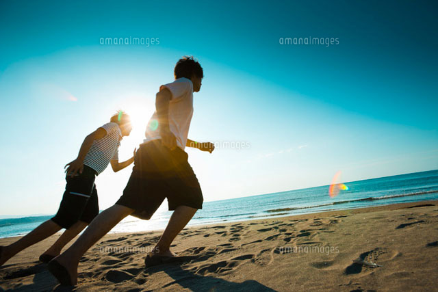 砂浜を走る2人の若い男性[11070004762]の写真素材・イラスト素材｜アマナイメージズ